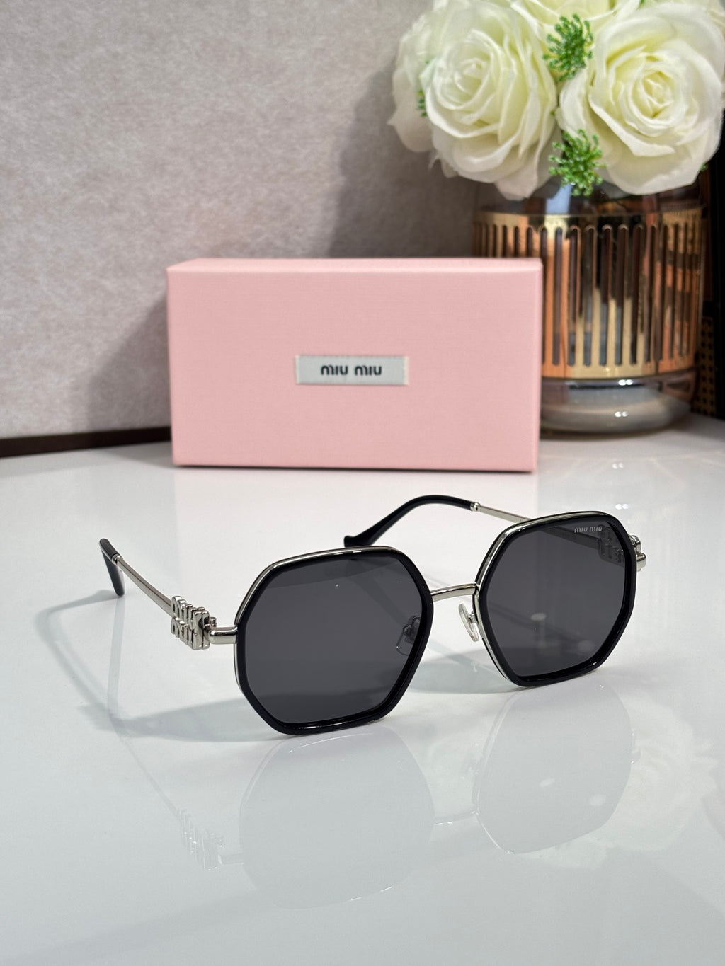 Square sunglasses with black frame and dark lenses, gold-toned temple hardware