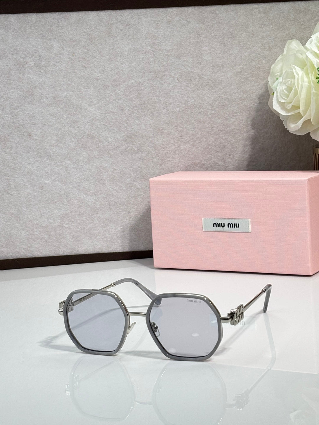 Round-edged square sunglasses with gray frame and dark lenses, metal temple hardware