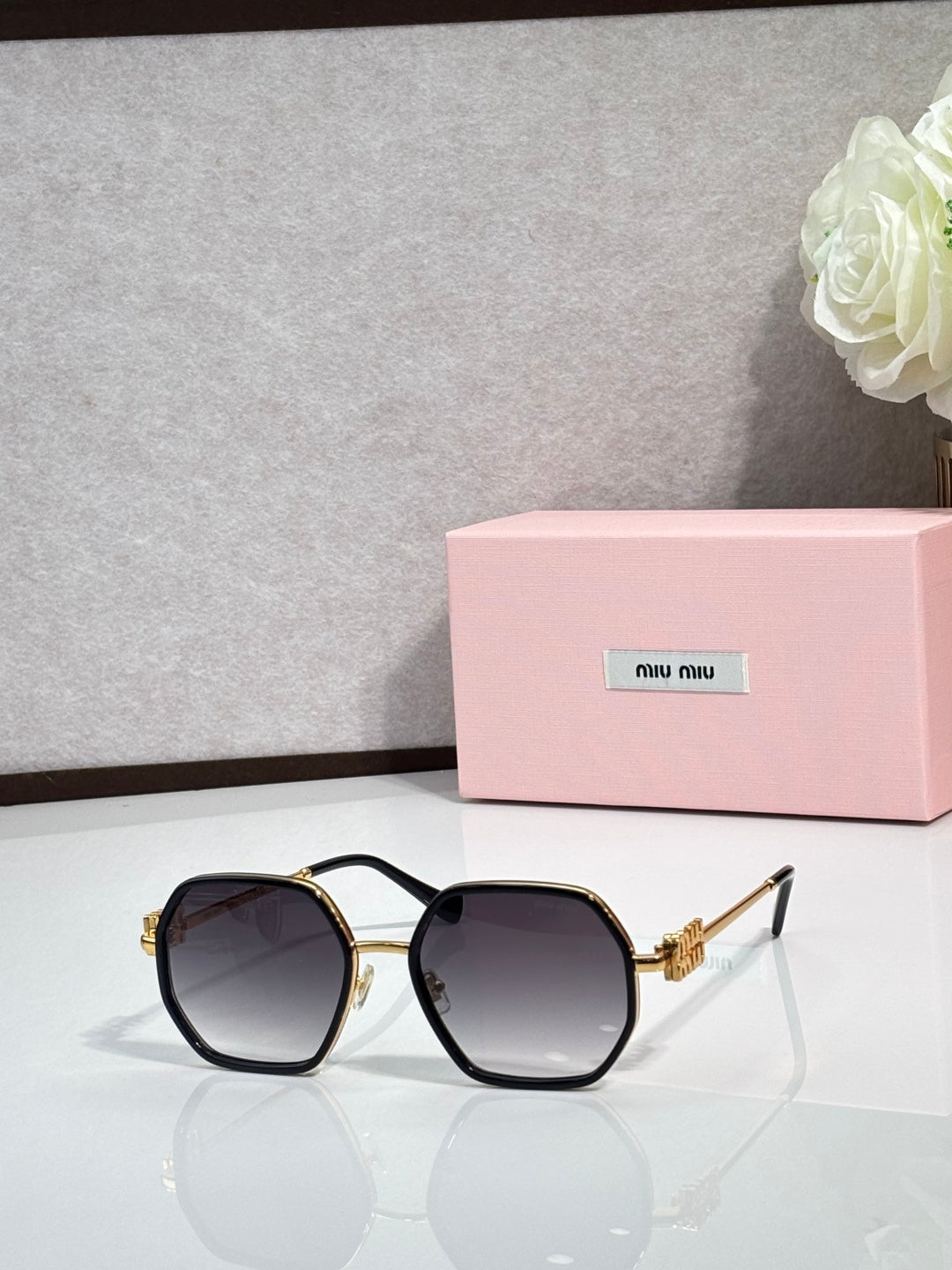 Square sunglasses with black frame, dark tinted lenses, gold-toned temple hardware