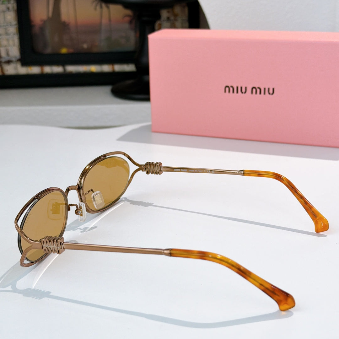 MiuMiu sunglasses with small oval gold frames, amber lenses, orange translucent temple arms