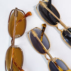 MiuMiu sunglasses set with gold-tone frames, amber and dark lenses, multiple pairs