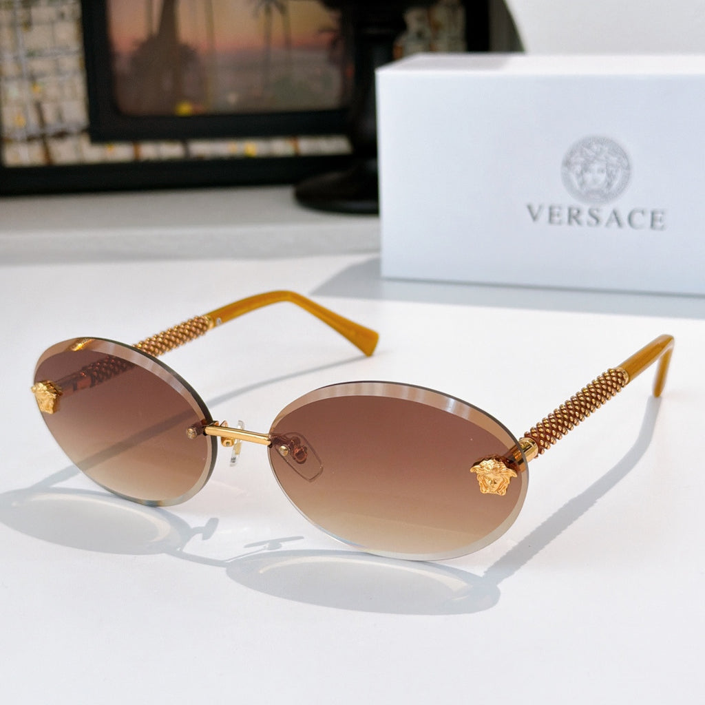 Round sunglasses with brown-tinted lenses, gold frame, and textured arms with charms