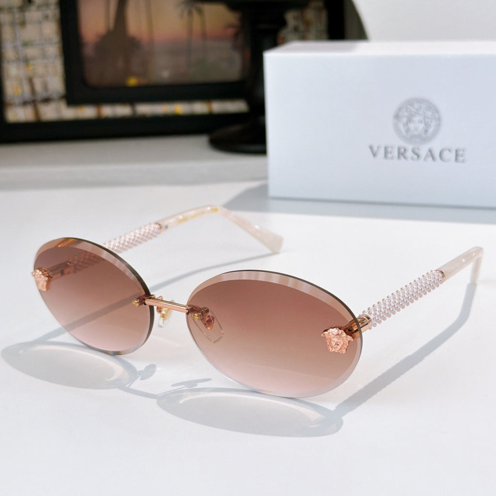 Round sunglasses with rose lenses, gold frame, and textured arms with star charms