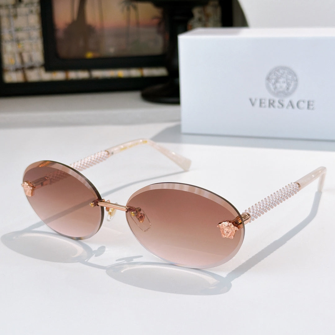 Round sunglasses with rose lenses, gold frame, and textured arms with star charms