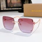 Pink gradient sunglasses with gold-tone frames and red temple accents
