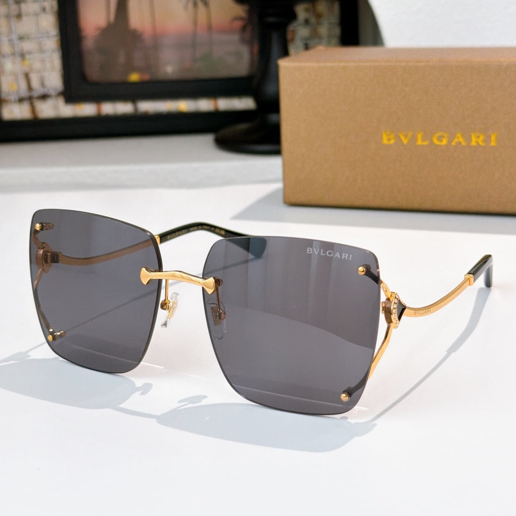 Gray gradient sunglasses with gold-tone frames and angular cat-eye shape