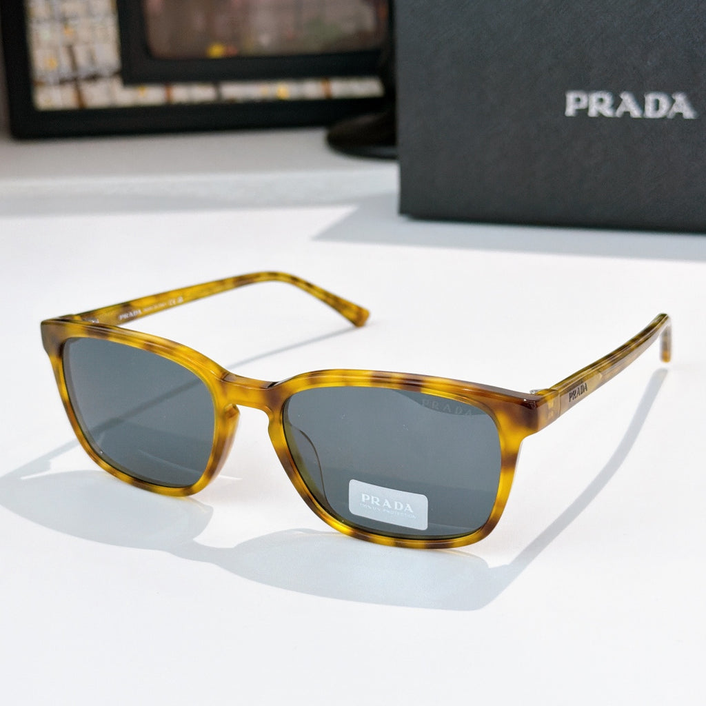 Prada sunglasses with amber tortoiseshell frame and gray-blue tinted lenses