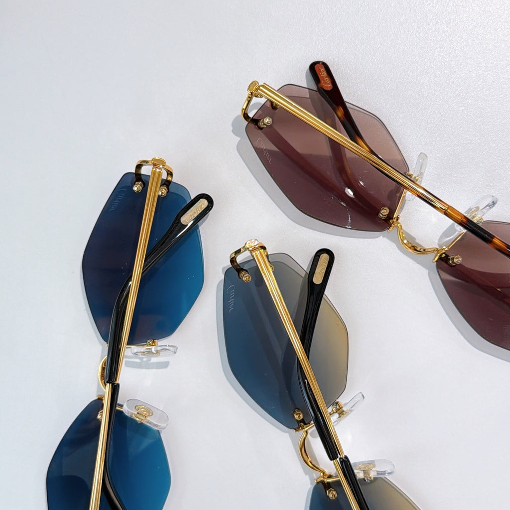 Gold-framed sunglasses with blue and dark brown tinted lenses, clear nose pads