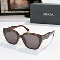 Prada sunglasses with brown tortoise frames and dark lenses, cat-eye style
