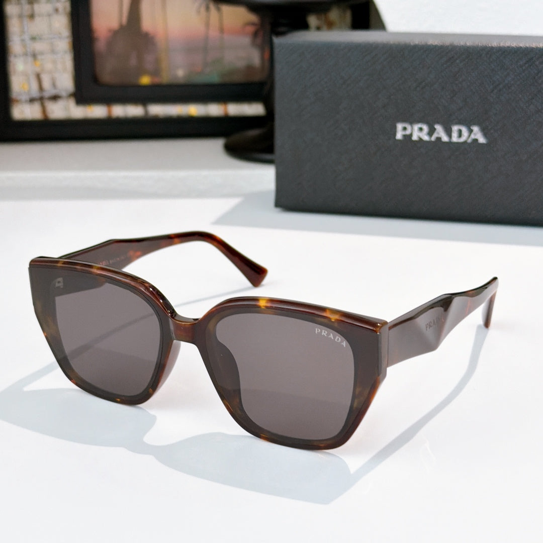 Prada sunglasses with brown tortoise frames and dark lenses, cat-eye style