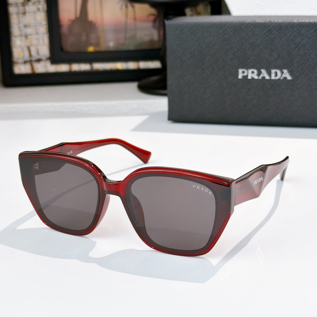 Prada sunglasses with red frames and dark lenses, cat-eye style