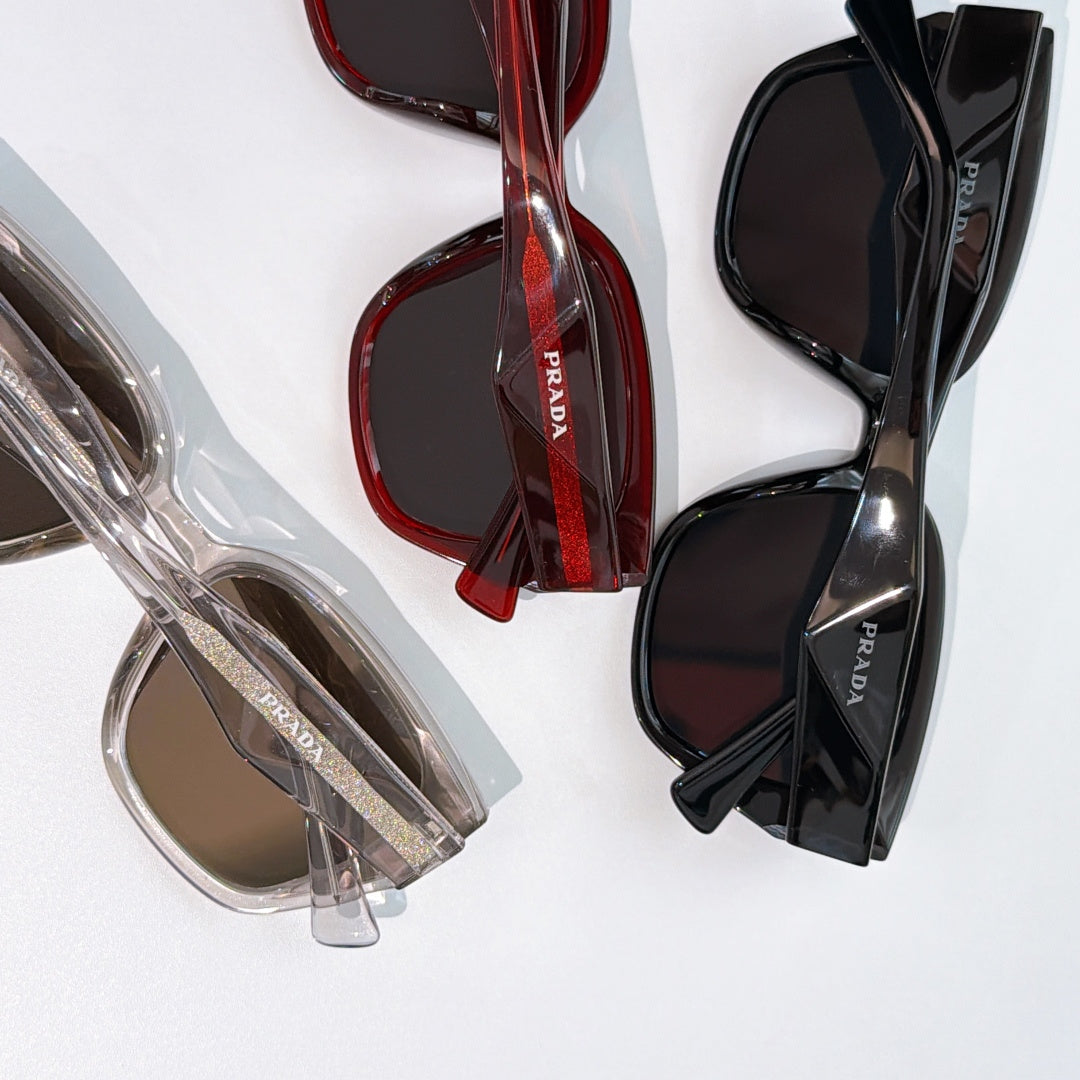 Prada sunglasses with red and black frames, dark lenses, overlapping pair views