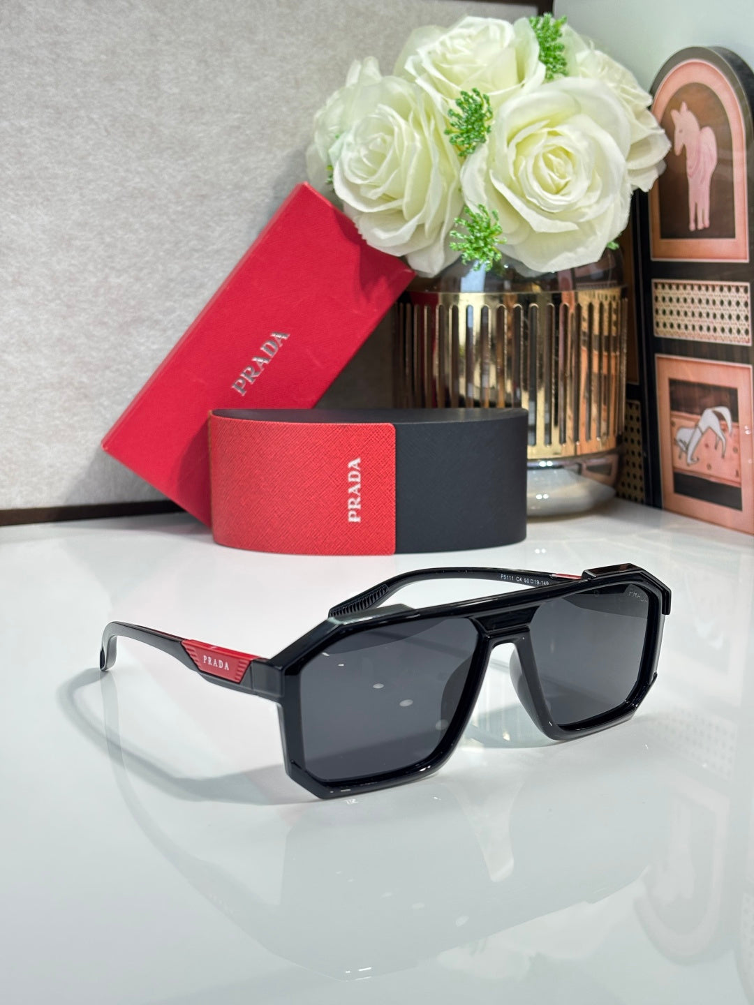 Prada sunglasses with black angular frames and dark tinted lenses