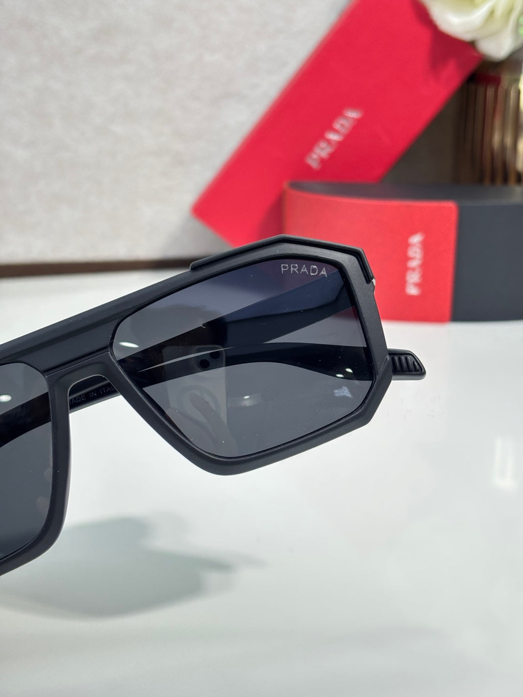 Prada sunglasses close-up of angular frame and dark tinted lens