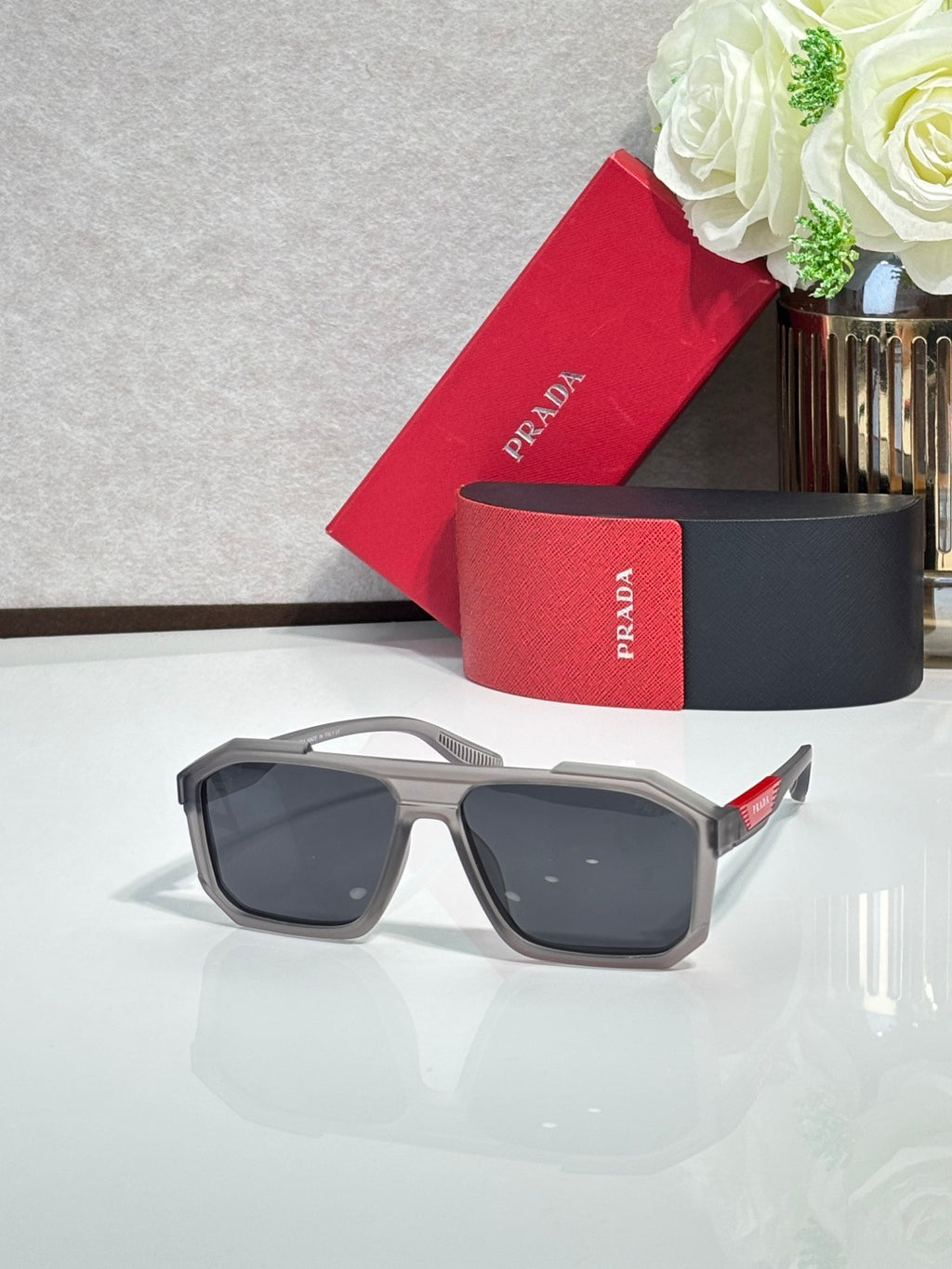 Prada sunglasses with light gray frames and dark rectangular lenses