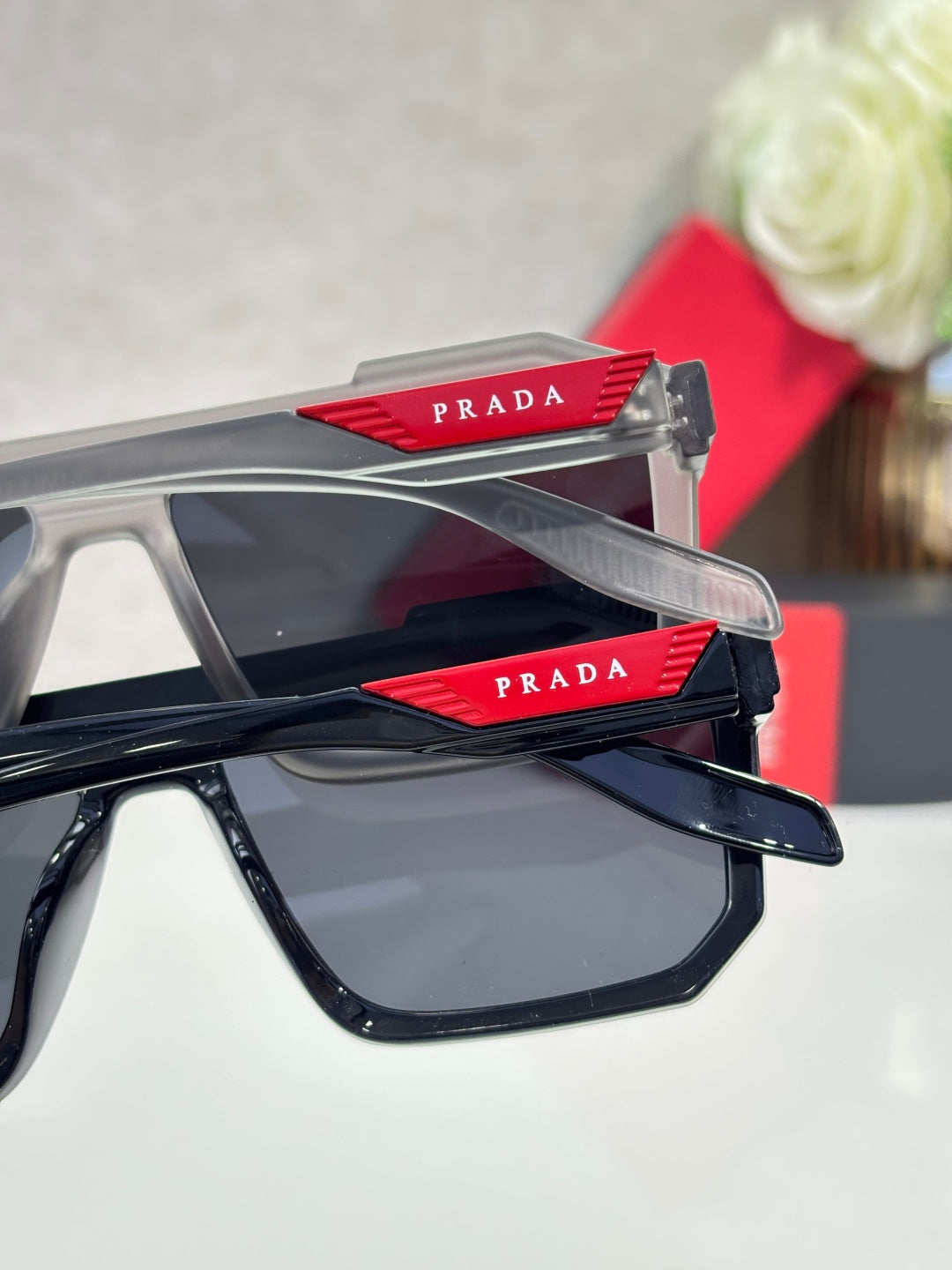 Gray and black sunglasses with dark lenses and Prada logo on temple tips