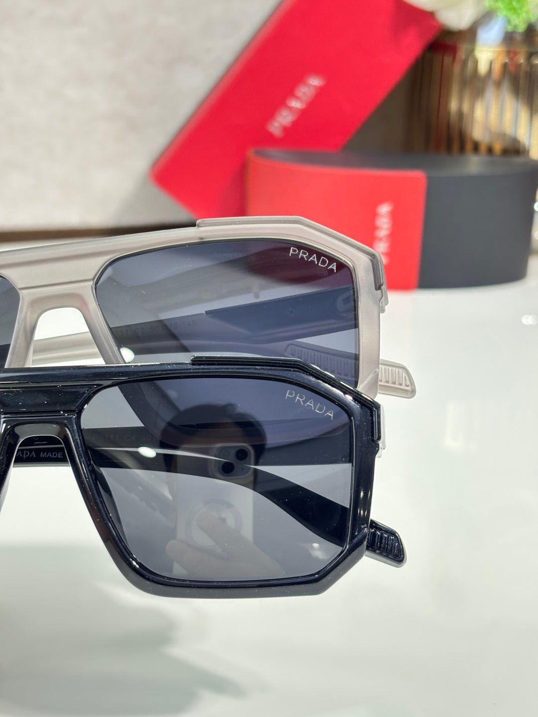 Gray and black rectangular sunglasses with dark lenses, Prada logo on temples