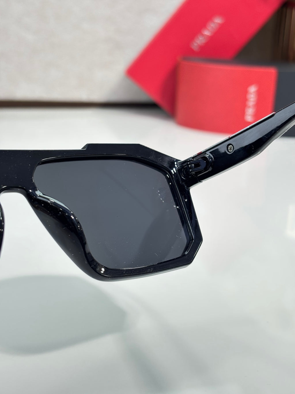 Black rectangular sunglasses with dark lenses and Prada logo on temple