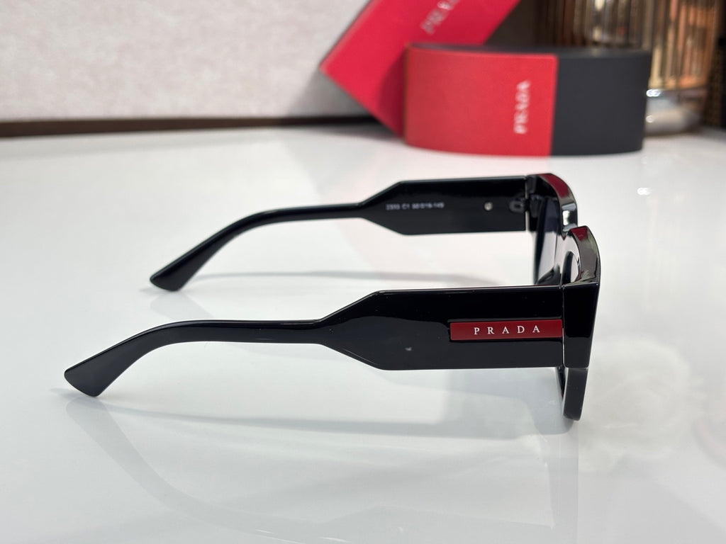 Black sunglasses side view with metal hinge and dark tinted lenses
