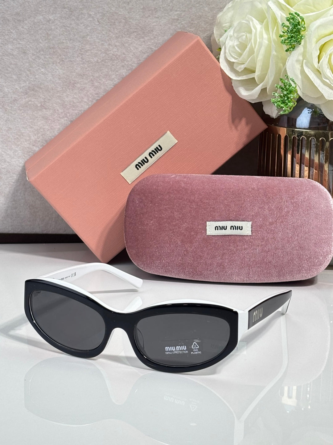 Black sunglasses with dark lenses; pink hard case and purple pouch included