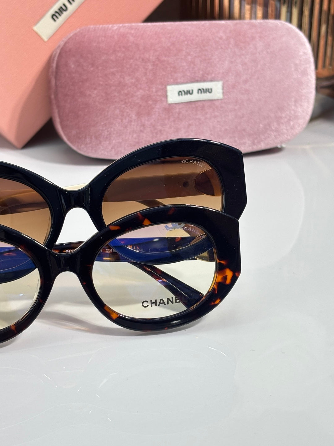 Round black sunglasses close-up with brown tinted lenses and logo on lens