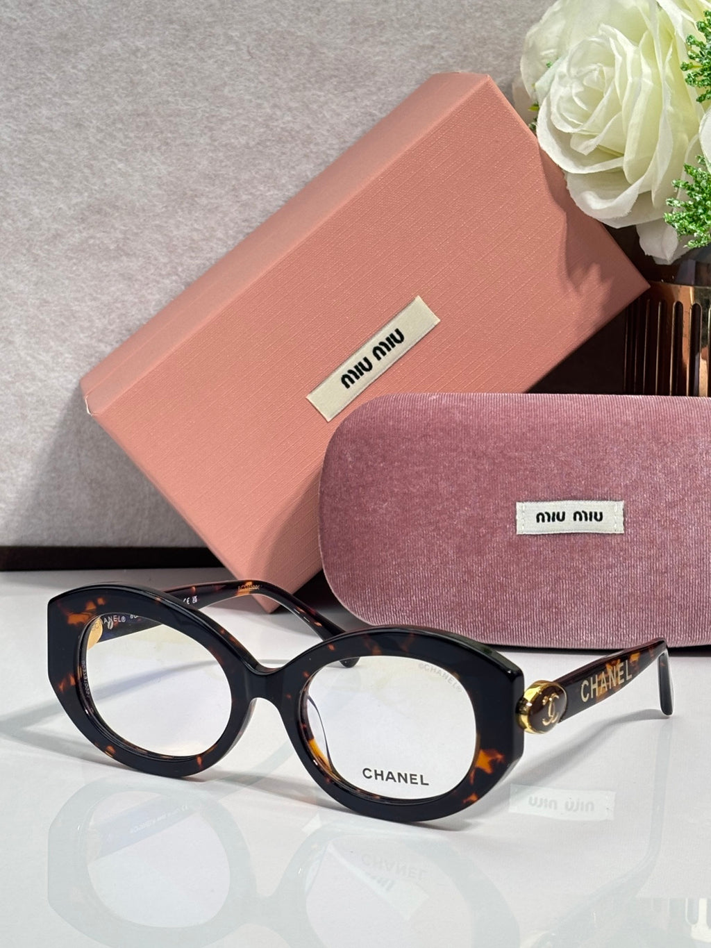 Round sunglasses with dark frames and clear lenses, gold detailing at temples