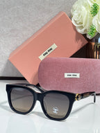 Chanel sunglasses with black frames and tortoise-patterned temples, dark lenses