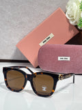 Chanel sunglasses with black frames, tortoise arms, and brown-tinted lenses