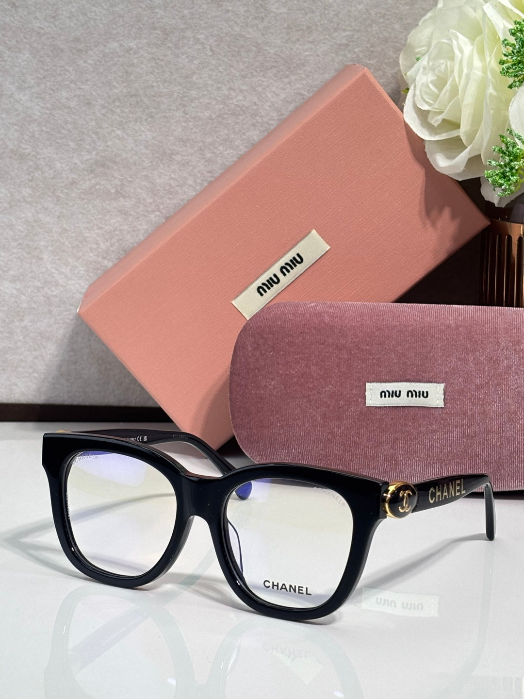 Chanel eyeglasses with black frames and tortoise-patterned arms, light-tinted lenses