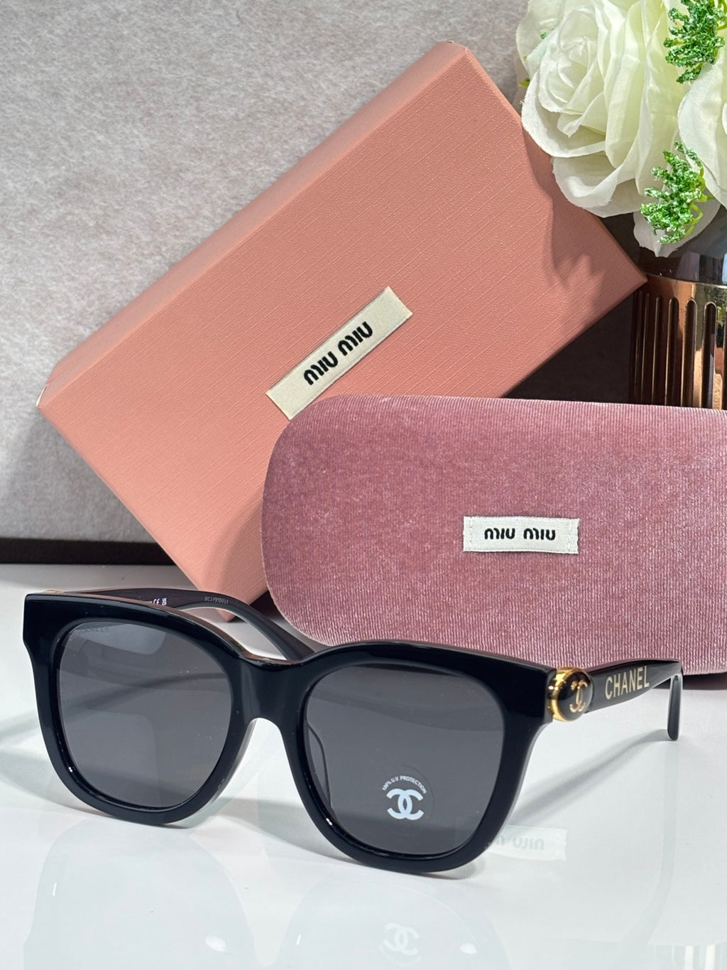 Chanel sunglasses with black frames and tortoise arms, oval dark lenses
