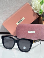 Chanel sunglasses with black frames and tortoise arms, oval dark lenses