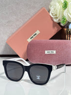 Chanel sunglasses with black frames and gold hinge detail, dark lenses