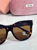 Chanel sunglasses close-up: black frame with tortoise temple and brown-tinted lens