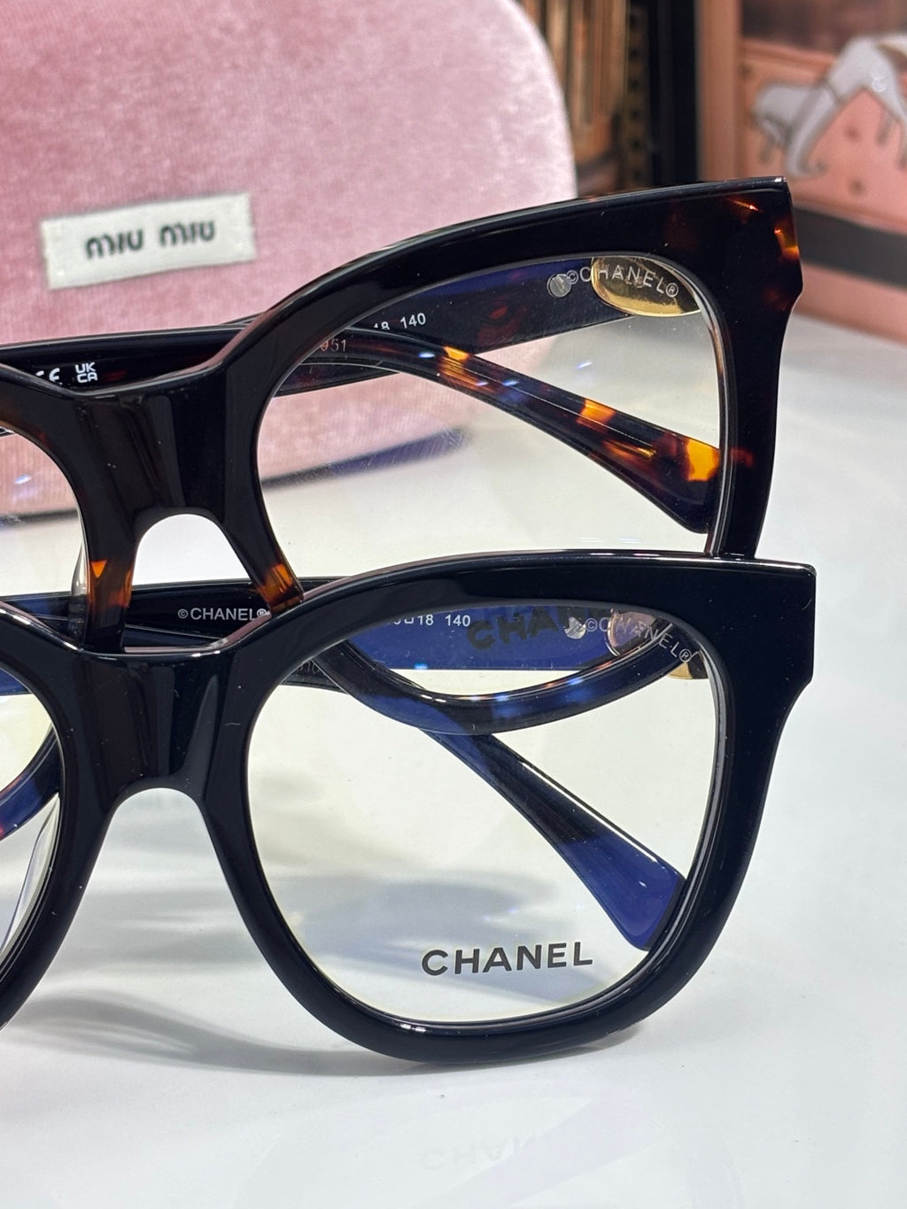Chanel sunglasses close-up: black frame with tortoise accents and blue-reflective lenses