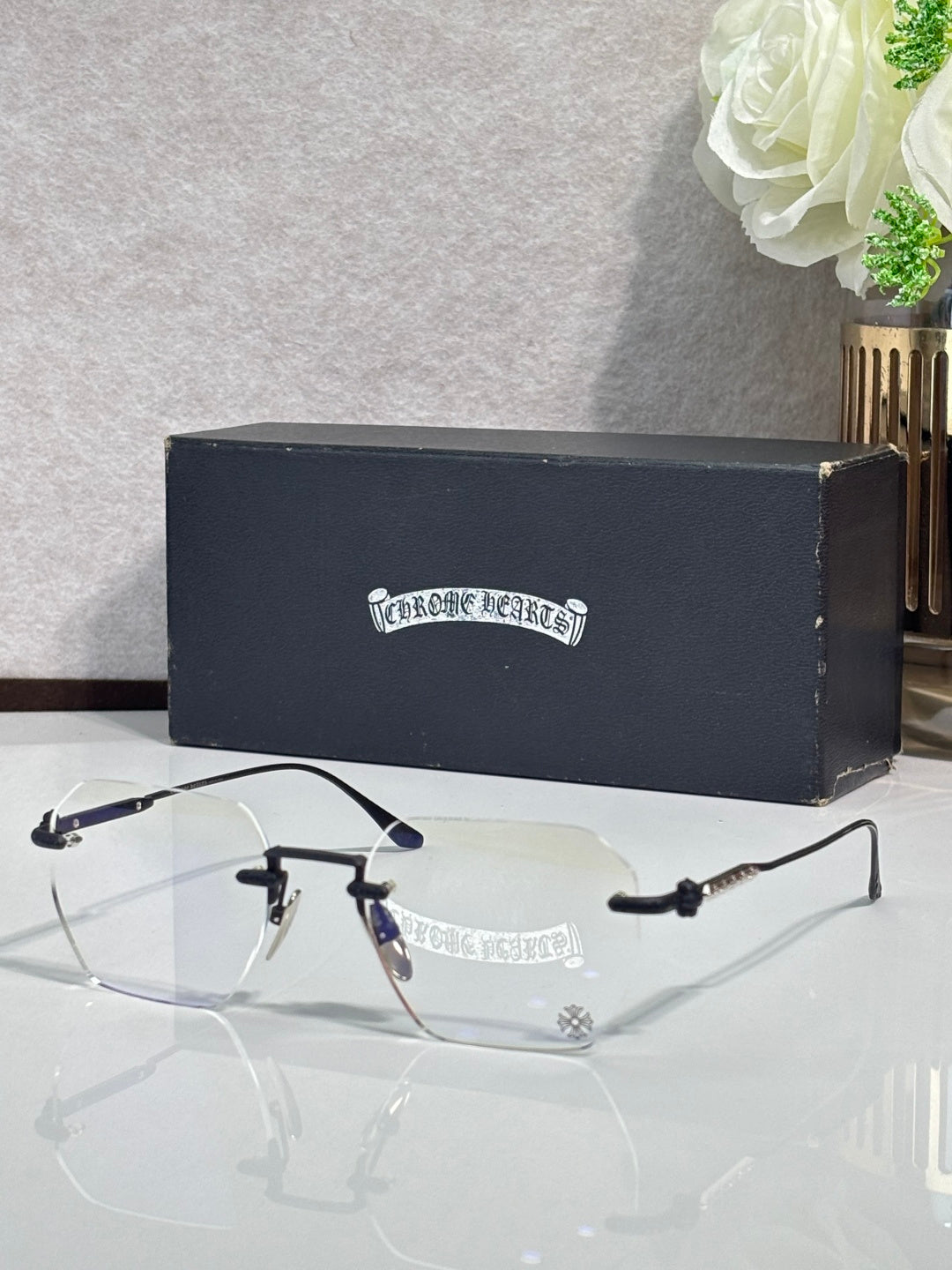 Dark navy metal eyeglasses with clear lenses and engraved temple logo detail