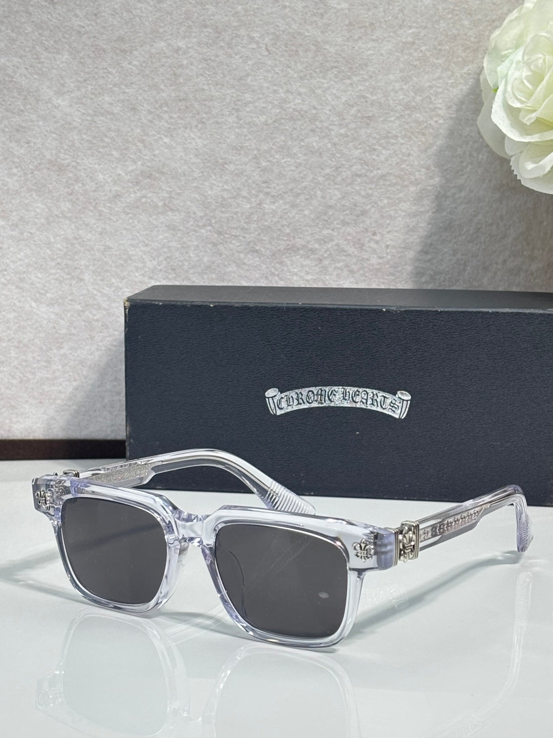 Transparent crystal-look sunglasses with chrome finish and dark lens panels