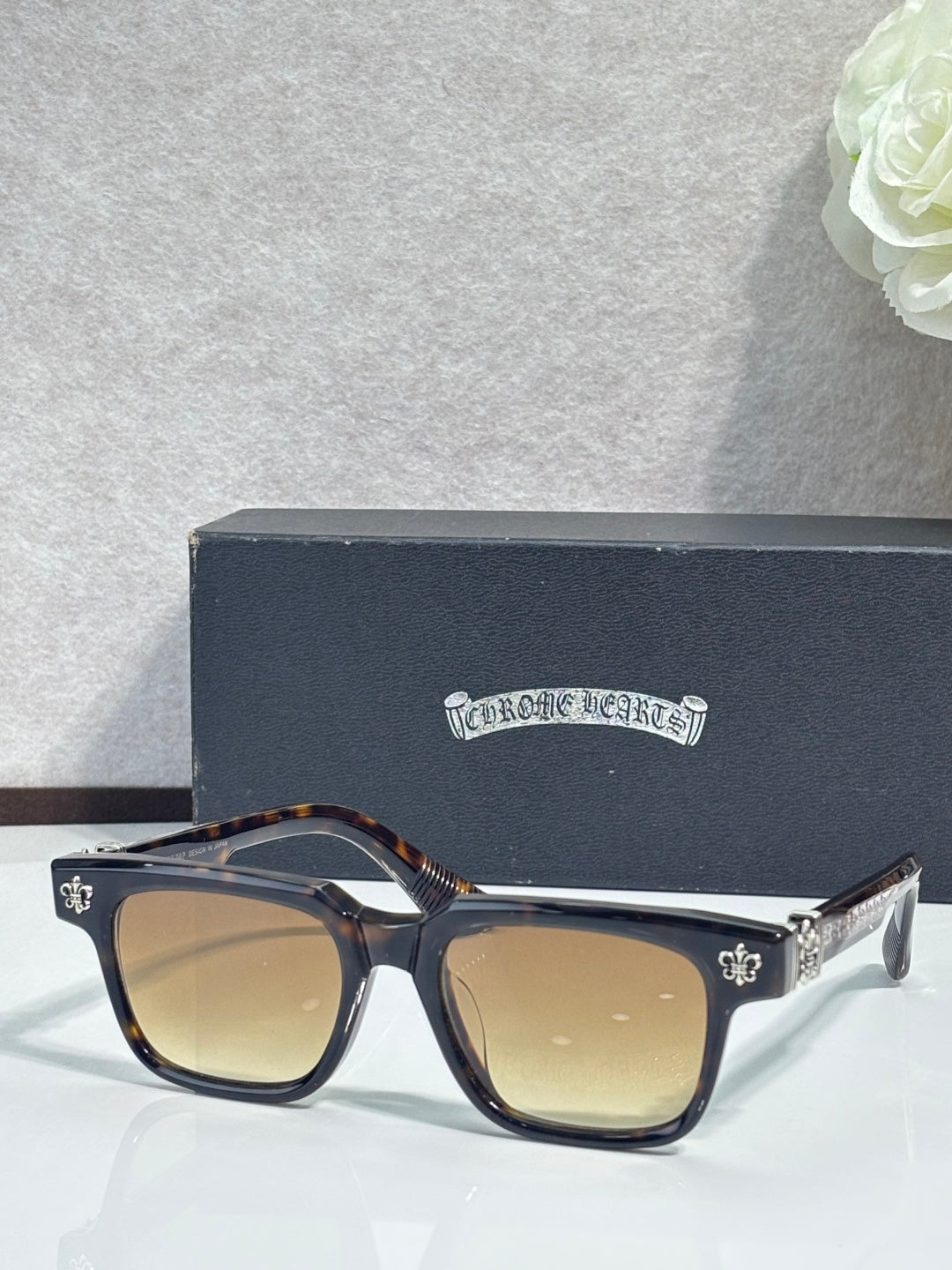 Tortoiseshell-accented sunglasses with chrome frame and gold fleur-de-lis details