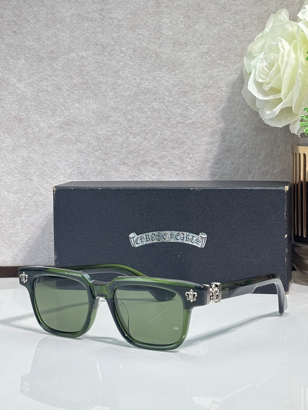 Green rectangular sunglasses with chrome frame and fleur-de-lis temple accents