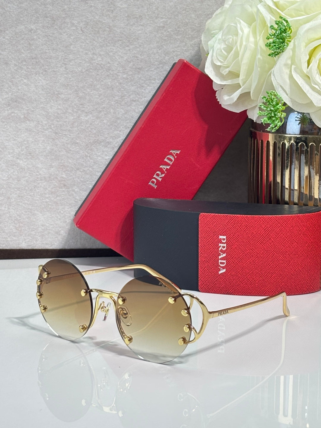 Prada round sunglasses with mirrored gold-tinted lenses and gold-tone frame