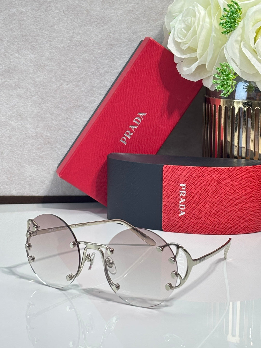 Prada round sunglasses with pale pink lenses and silver-tone metal frame