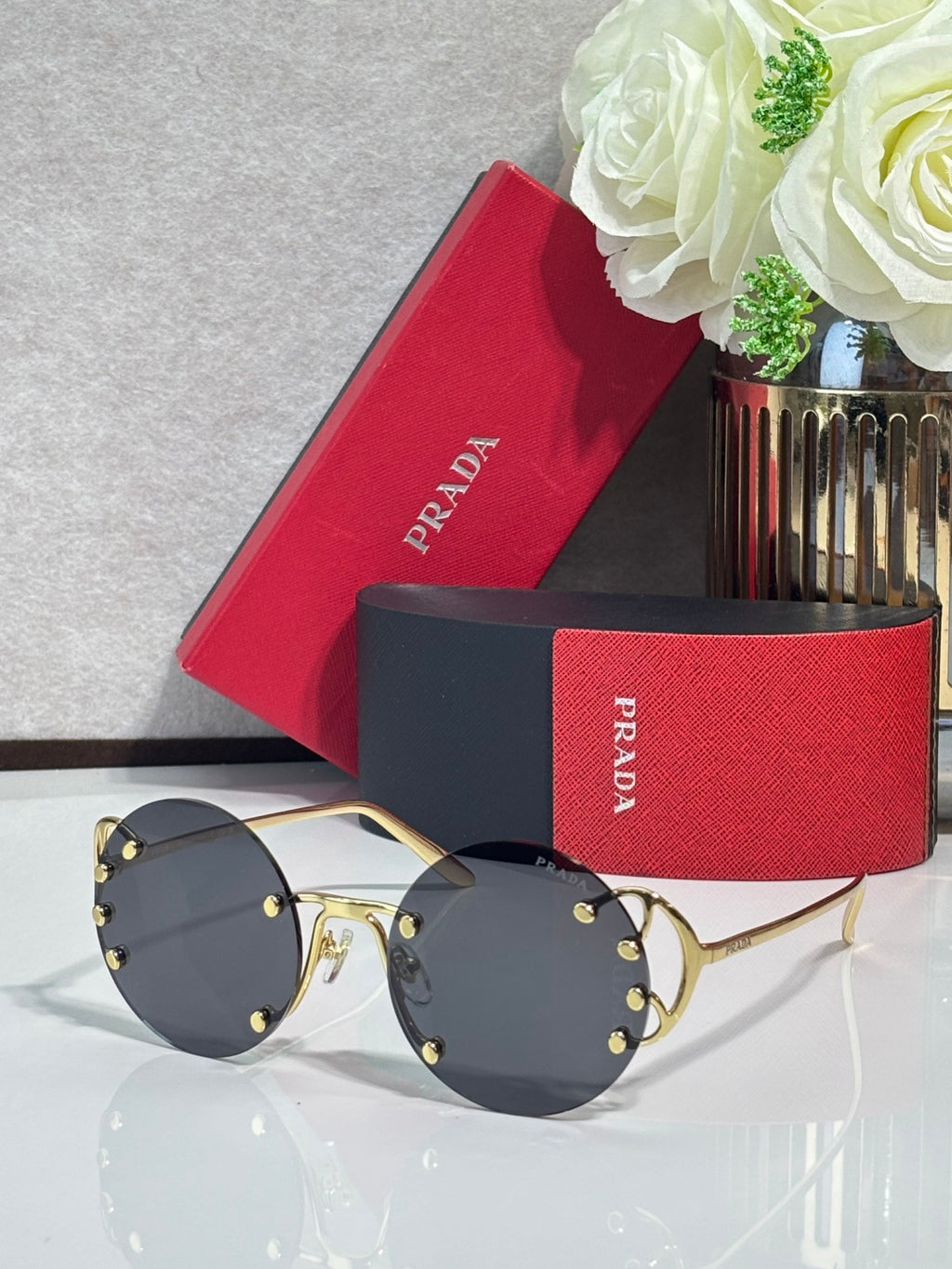Prada round sunglasses with dark lenses and gold-tone metal frame