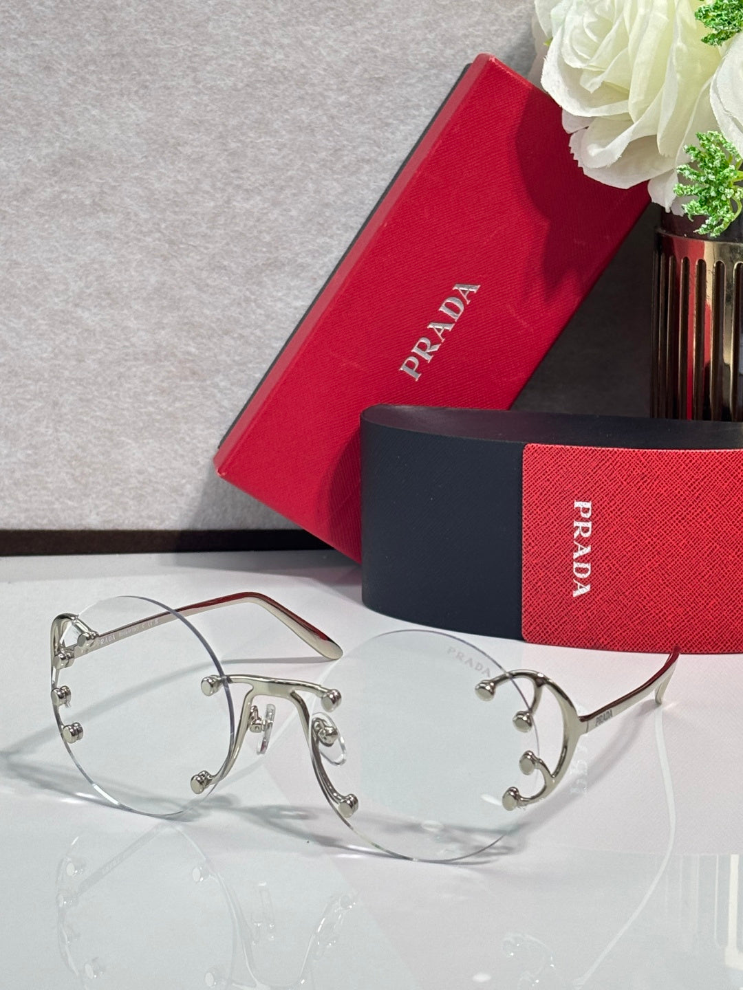 Prada round sunglasses with clear tinted lenses and silver-tone metal frame