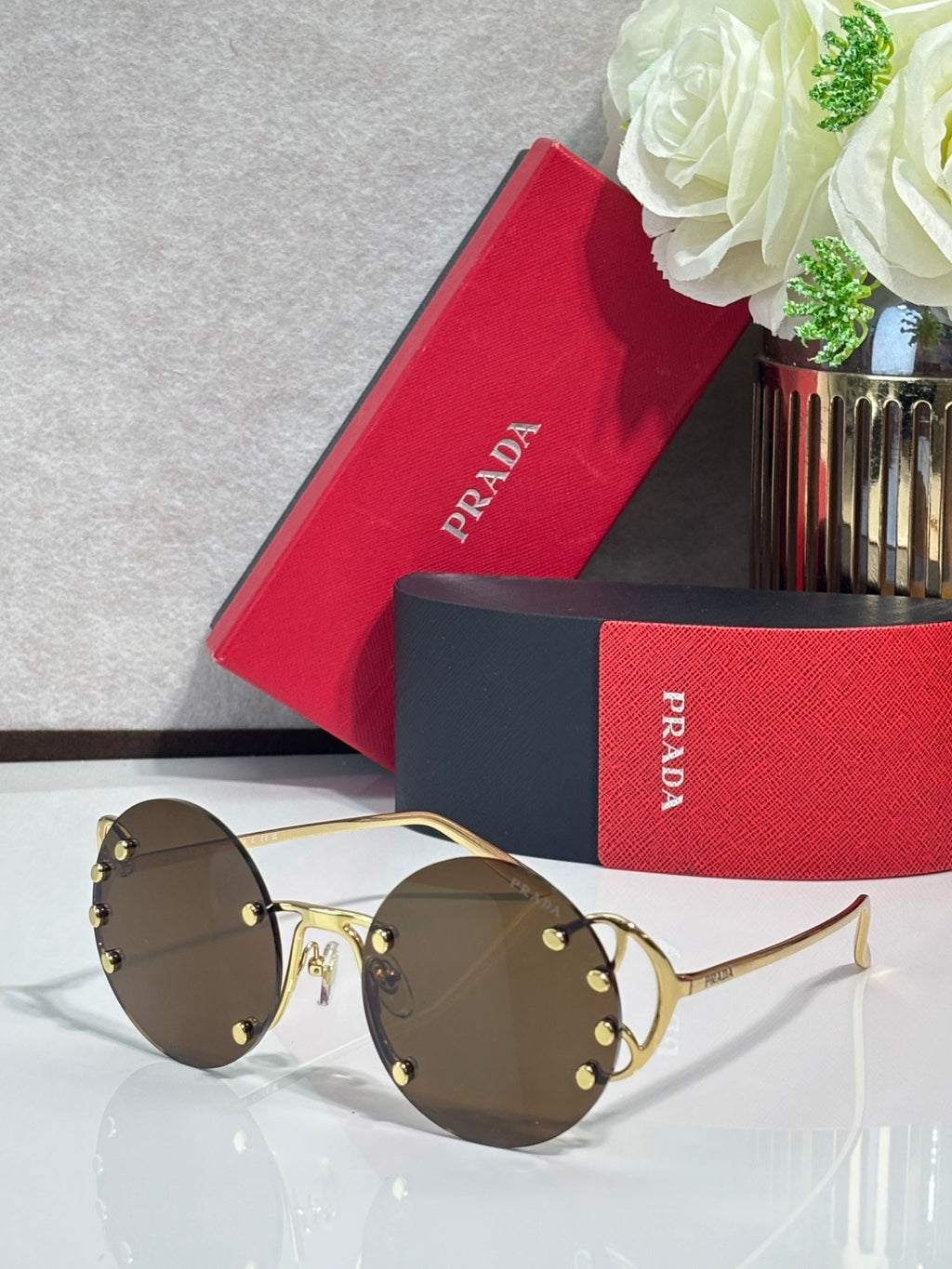 Prada round sunglasses with dark lenses and gold-tone metal frame