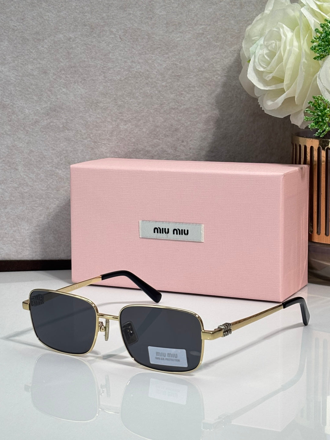 Gold-tone square sunglasses with dark navy lenses and black temple tips