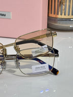 MiuMiu gold metal eyeglasses with clear lenses and logo temple details