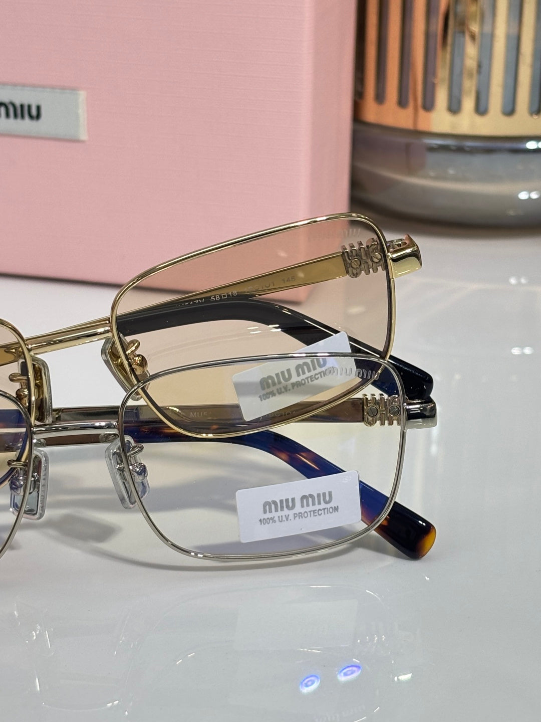 MiuMiu gold metal eyeglasses with clear lenses and logo temple details