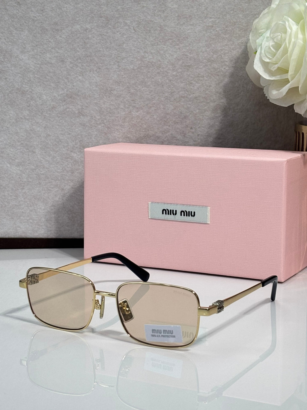 Gold-tone square sunglasses with light amber lenses and black temple tips
