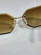 Close-up hexagon sunglasses with yellow lenses and gold-tone metal bridge