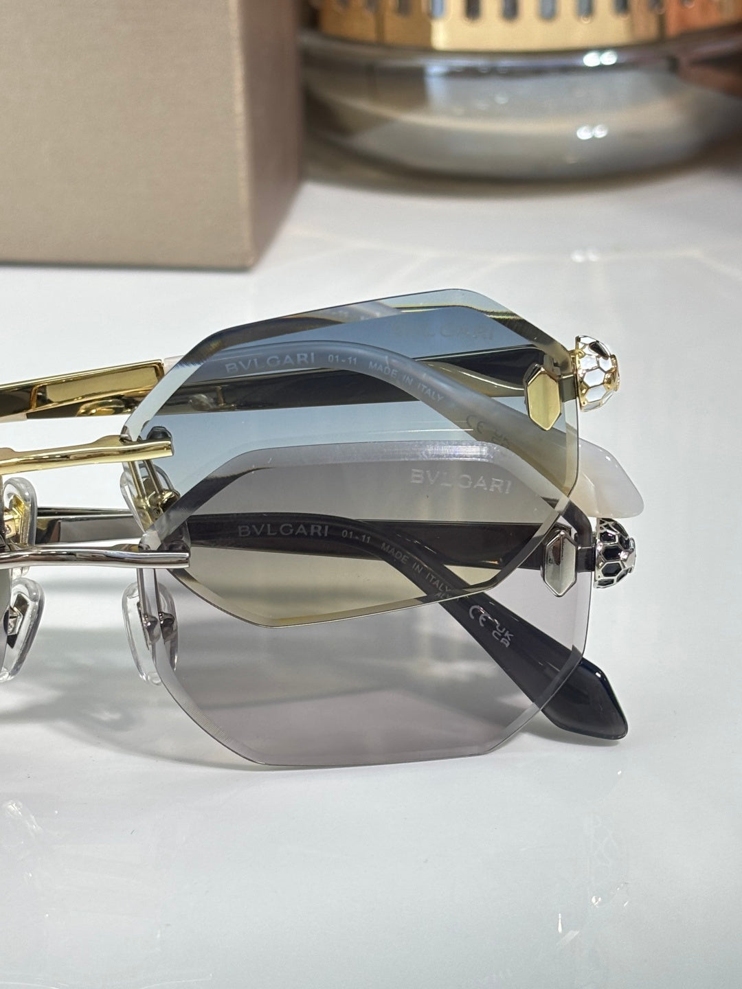 Hexagon sunglasses with blue-gray lenses, gold-tone frame and dark bridge