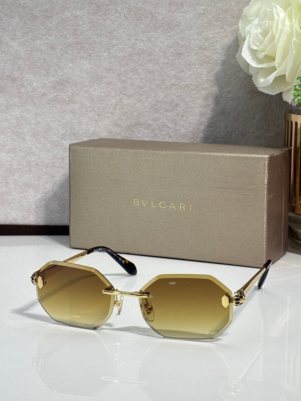 Hexagon sunglasses with yellow-tinted lenses, gold-tone frame and dark blue temples